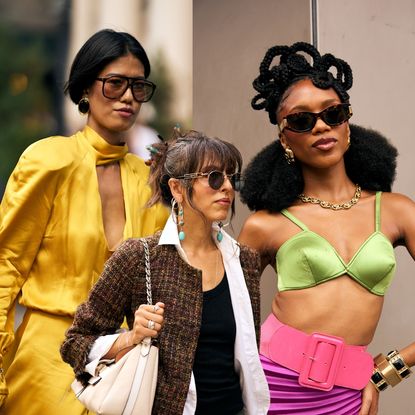 three woman in stylish outfits with sunglasses at NYFW