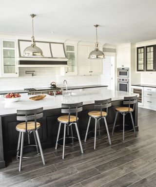 Kitchen layout ideas with L-shaped kitchen with white cabinets and black island with breakfast bar
