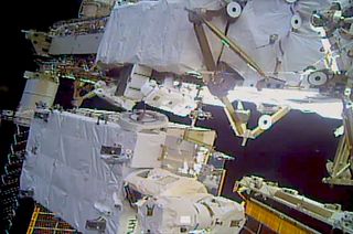 NASA astronauts Jessica Meir and Christina Koch, at center on either side of a protruding battery, work outside of the International Space Station during on a spacewalk on Monday, Jan. 20, 2020.