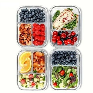 Four glass food storage dishes with dividers, food inside. 