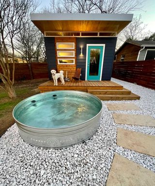 stock tank pool from Cowboy Pools on gravel with garden building