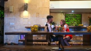 dom and georgia netflix's perfect match talking at a table outside the villa