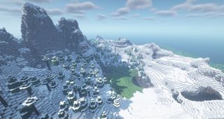 Minecraft - snowy peaks surrounding a small grassy meadow valley.
