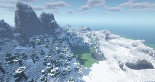 Minecraft seeds - snowy peaks surrounding a small grassy meadow valley.