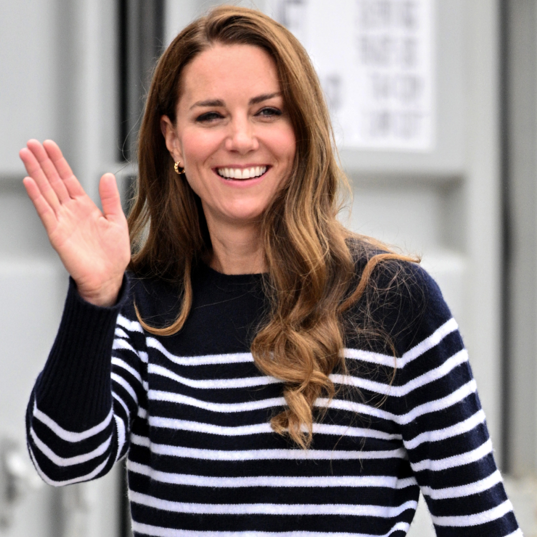Kate Middleton waving in a navy striped sweater