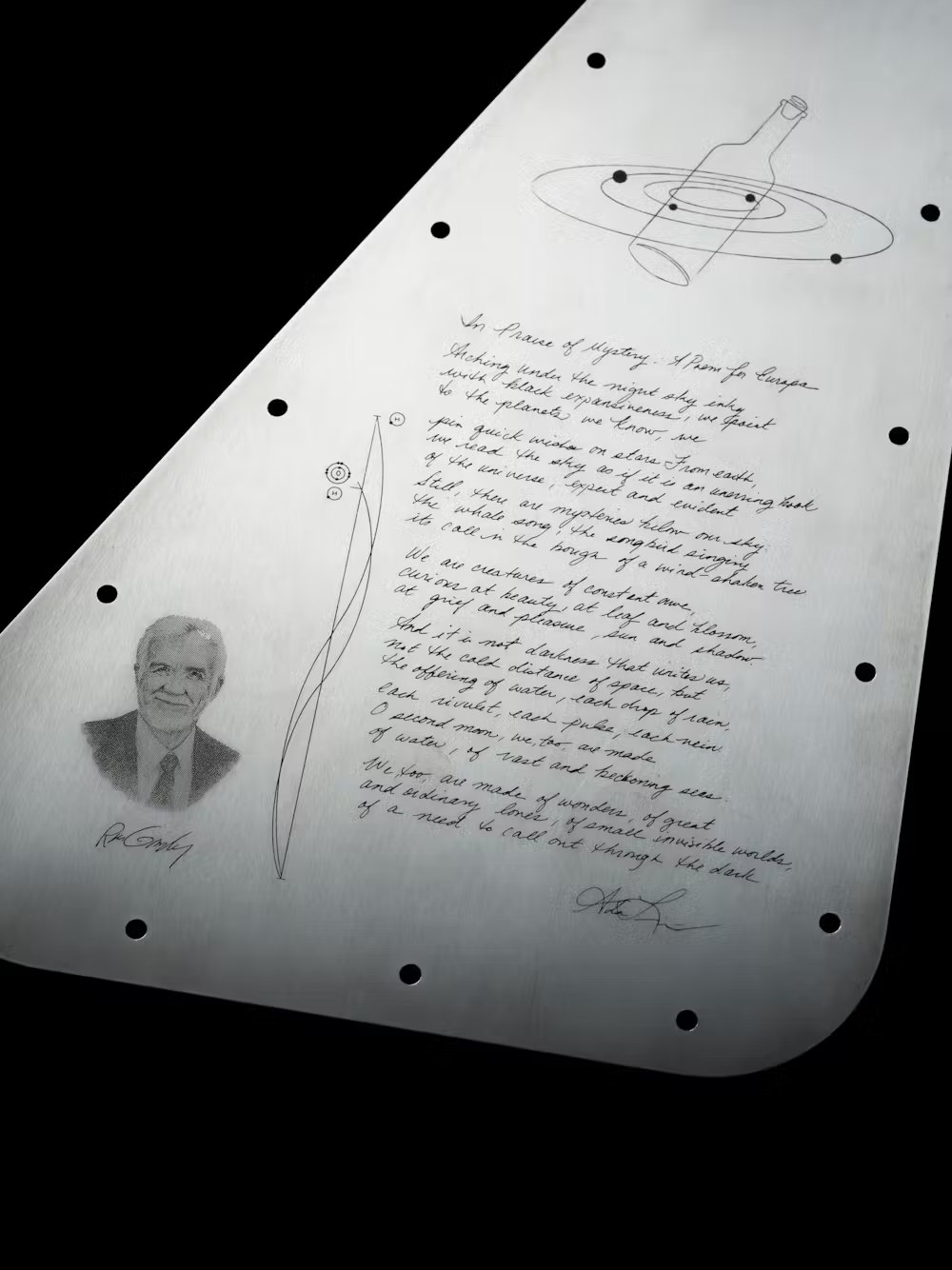 a triangular metal plate with curved corners and an etching of an a handwritten letter and someone's face on the surface.