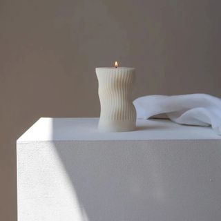 Wavy cream-colored candle on a stand