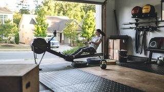woman working out on rowing machine in home gym in garage