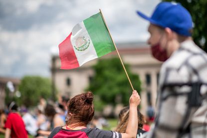 Woman holding Mexican flag.