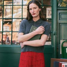 Campaign image from J.Crew january 2025 new arrivals model wearing the Brushed Cashmere Short-Sleeve Sweater-Polo and Pleated Knee-Length Skirt in Bow-Print Viscose Chiffon