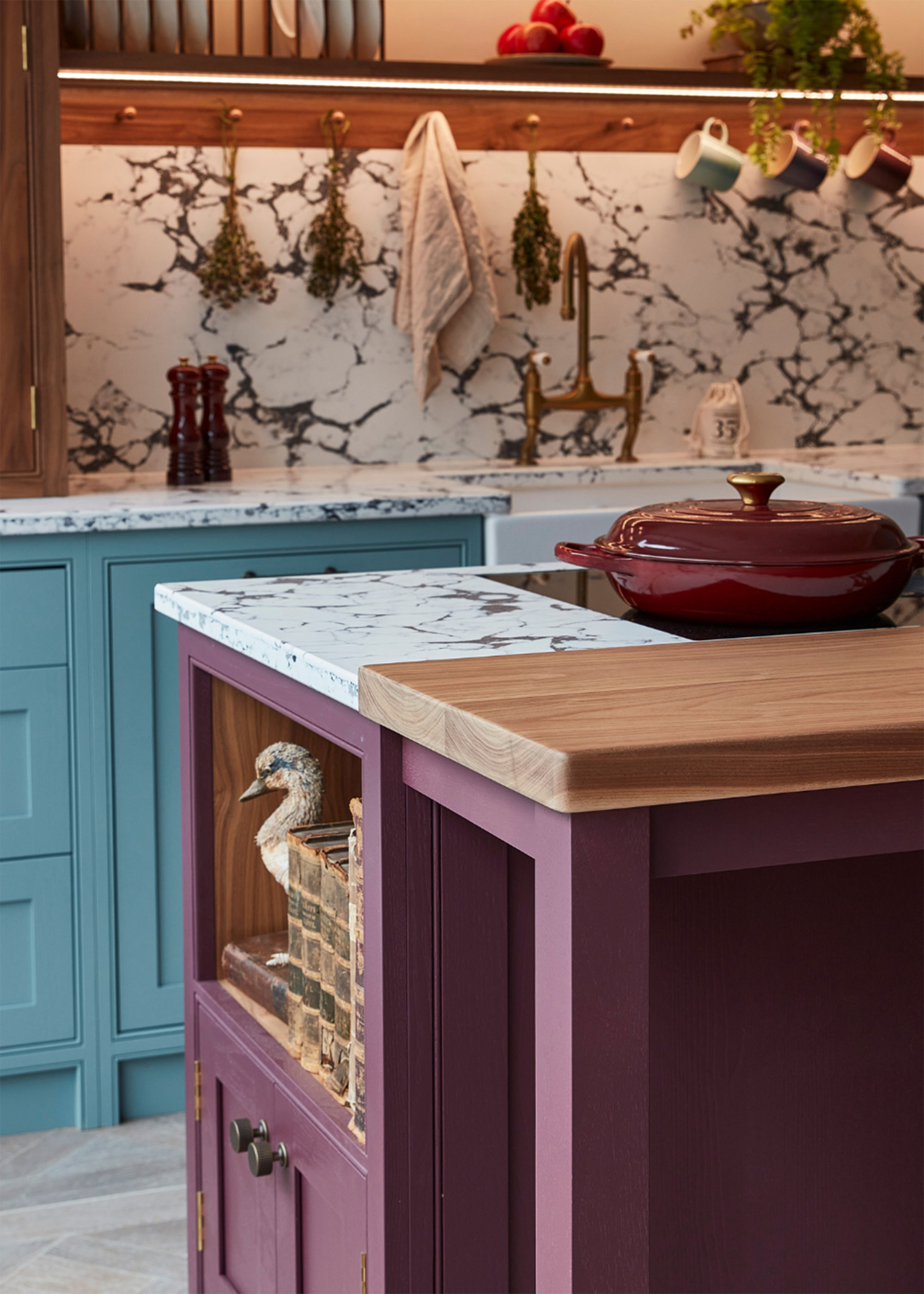 purple kitchen island with blue kitchen cabinets and marble backsplash