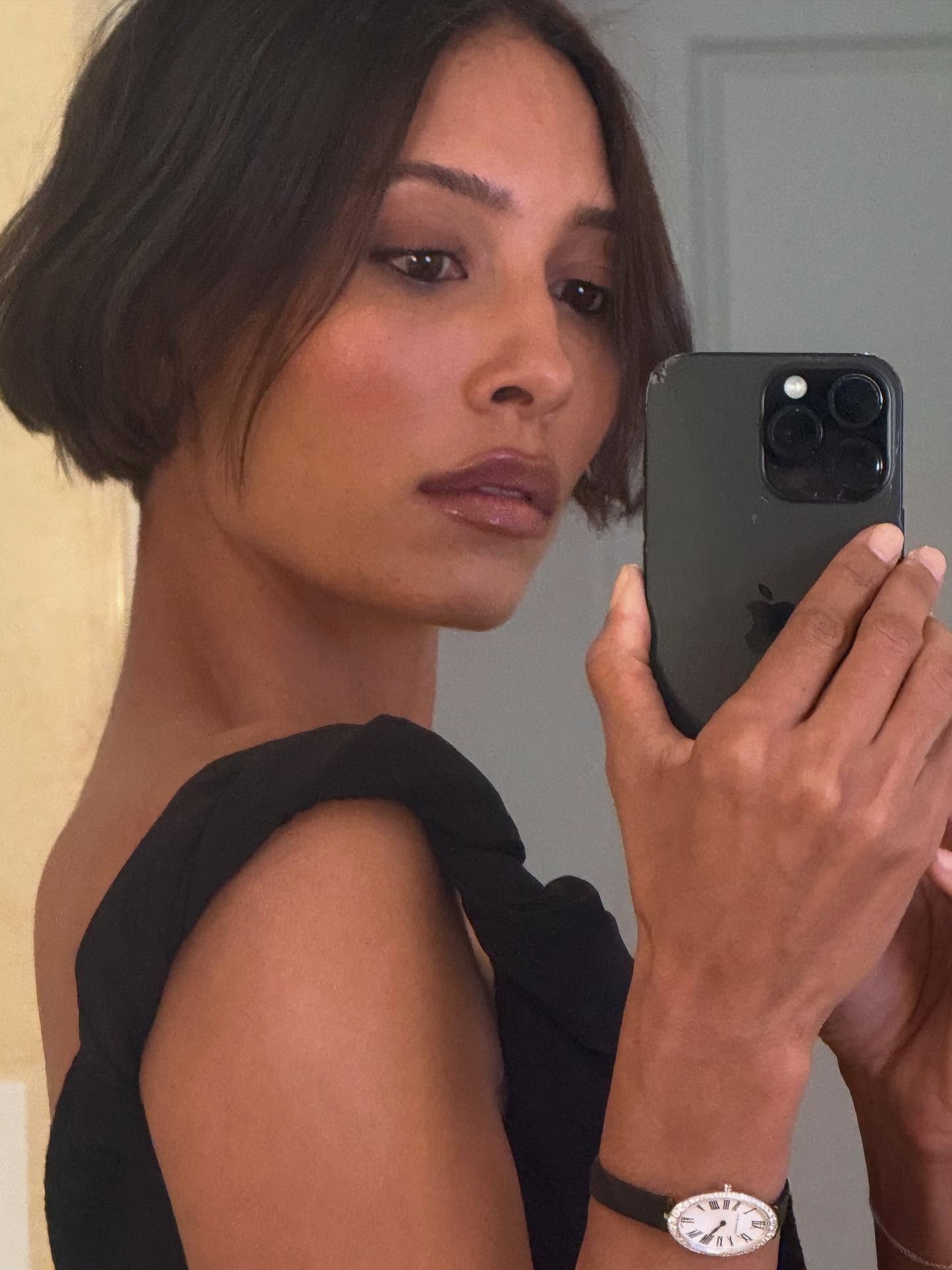 A woman taking a mirror selfie with a super short serrated bob