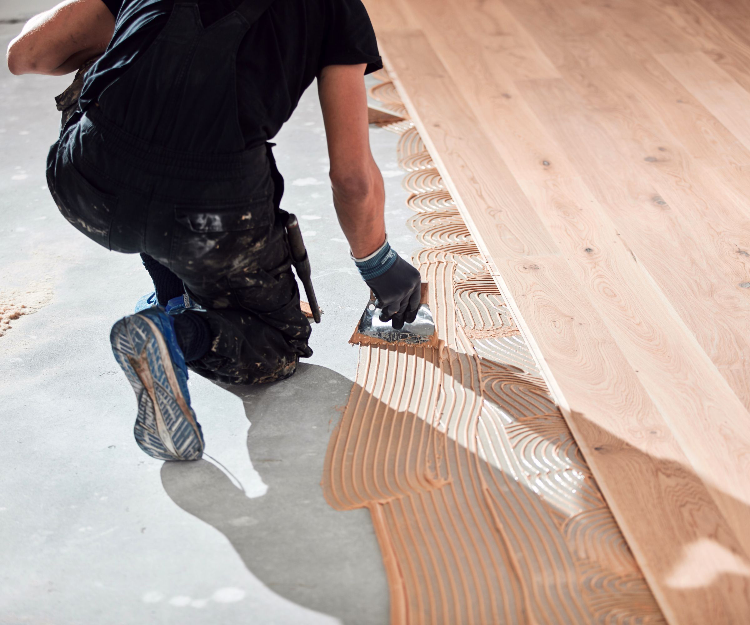 Professional handyman installing laminate flooring in a new apartment