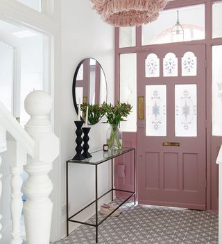 hallway with pink painted front door and pink pendant light