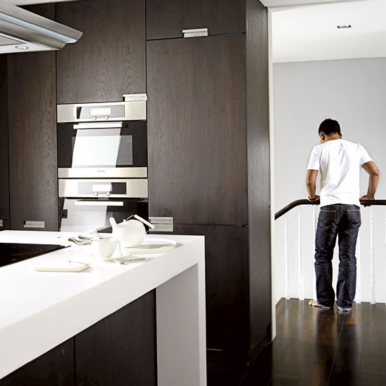 kitchen with dark wooden cabinet and person