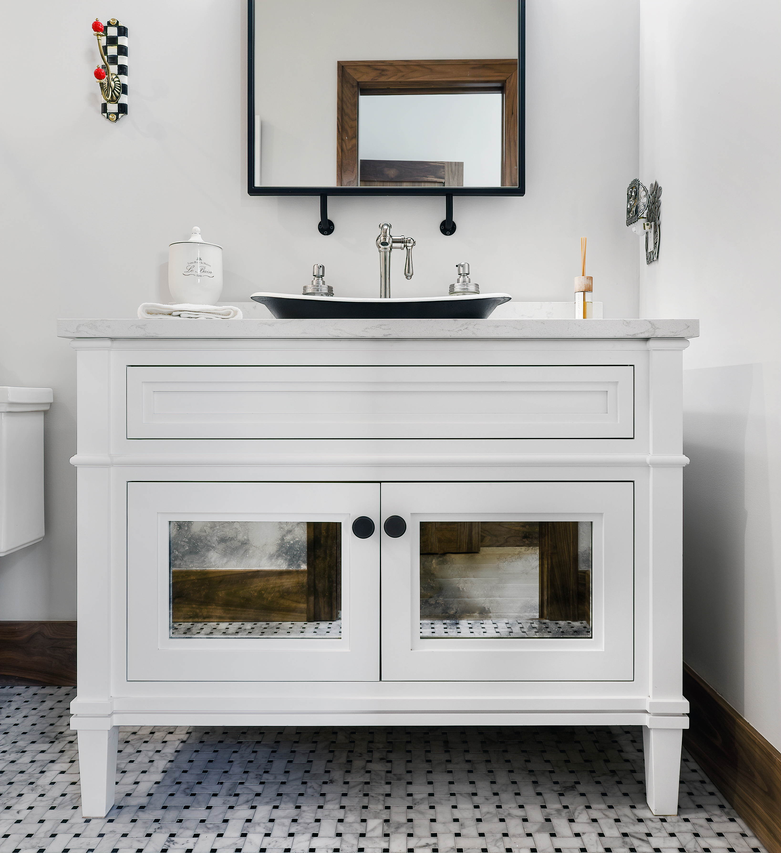 meuble sous-vasque blanc dans une salle d'eau blanche avec lavabo noir et miroir