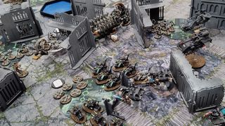 Warhammer 40,000 10th Edition being played on a ruined battlefield, with Space Marines taking on Necrons