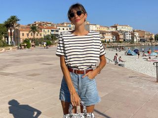 a French woman wears a striped T-shirt with denim shorts