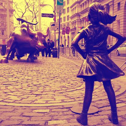 Fearless Girl statue facing the Wall Street Bull.