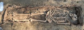 Skeleton uncovered in grave.