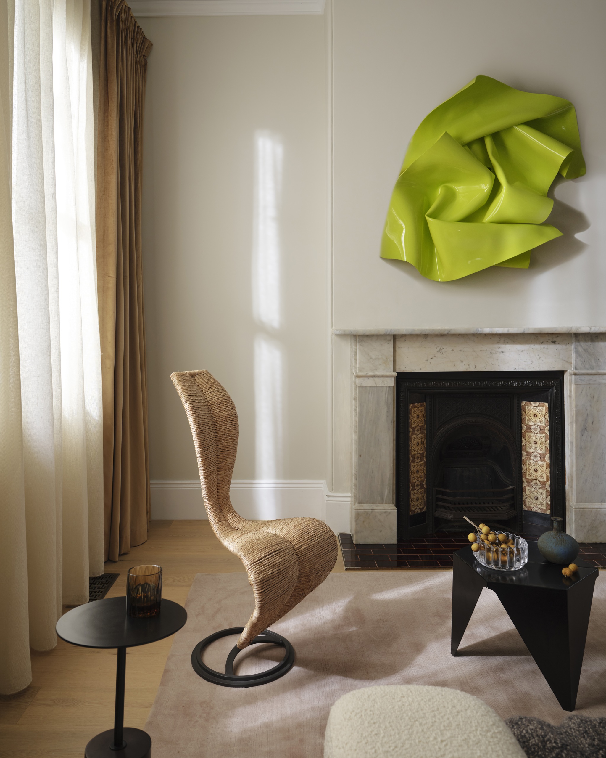 a living room with a tom dixon s chair and acidic green wall art
