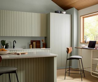 Modern rustic kitchen with wood panelled cabinetry painted in a pale green hue