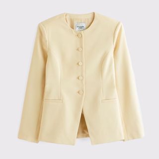 A cutout of a pale yellow collarless blazer