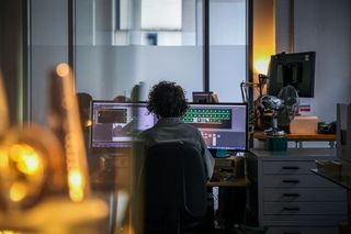 Lux Aeterna AI tools; someone sits at a desk in a VFX studio