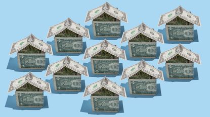 Several houses made from dollar bills are lined up.