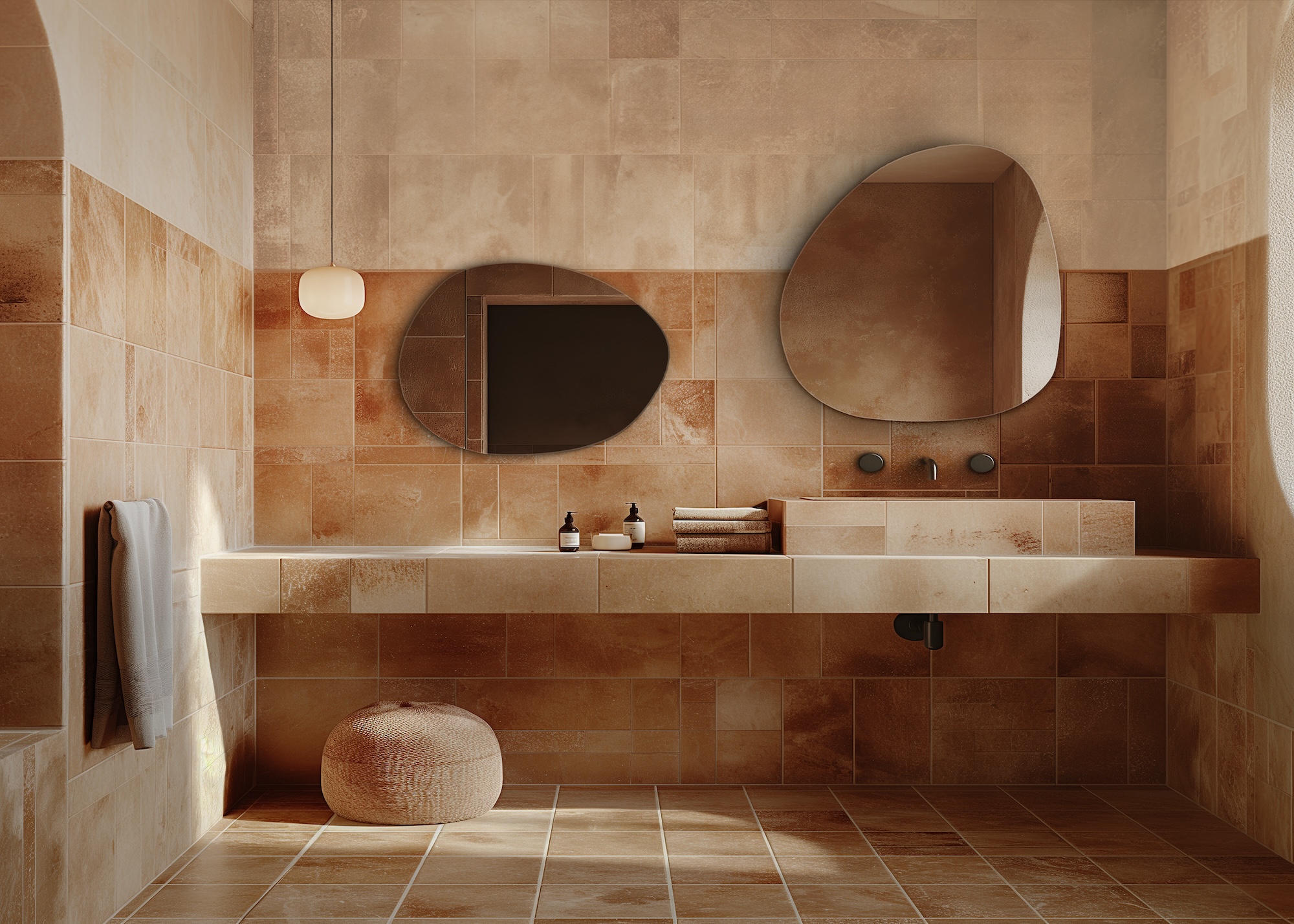 A bathroom with two mirrors in a soft curved shape above a basin. The bathroom is a soft two tile space with a small pendant light hanging in the corner of the room