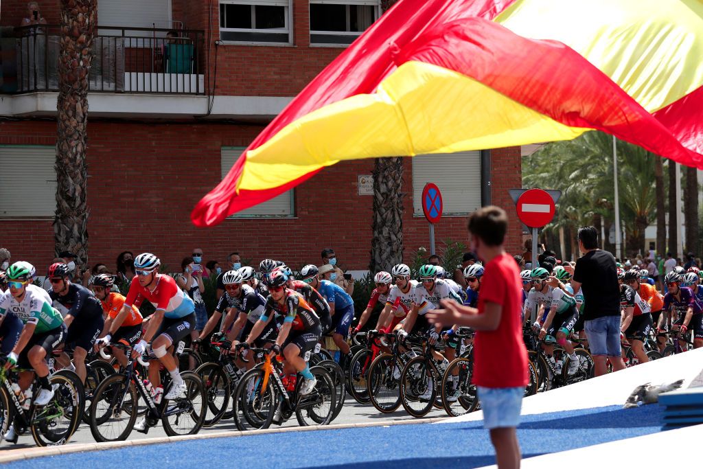 A Spanish flag waves in the breeze as the Vuelta a Espa&ntilde;a goes past