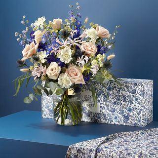 flower in vase with box and blue wall