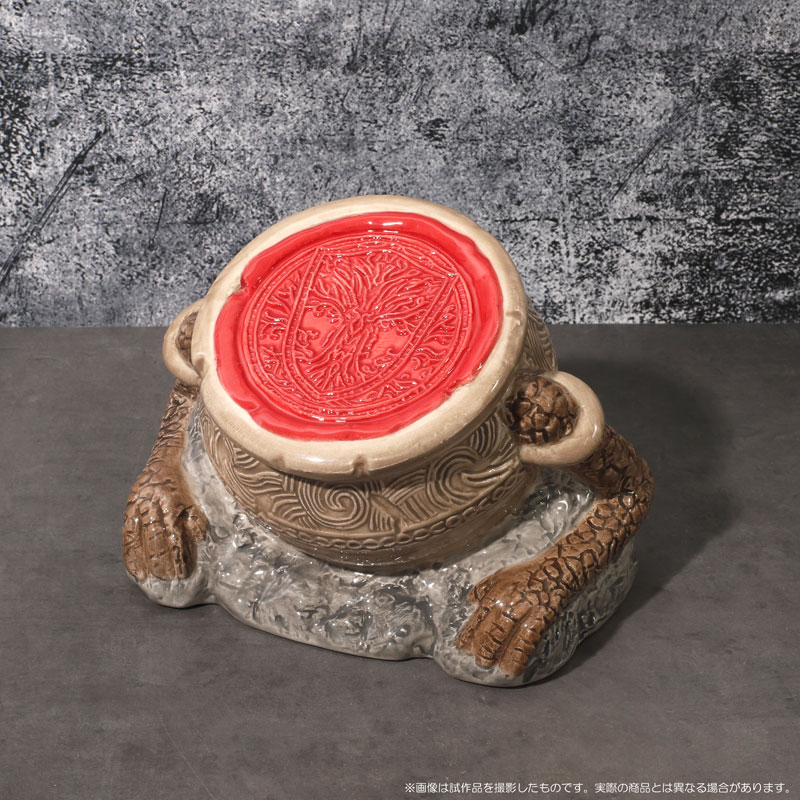 Images de bibelots réels d'Elden Ring, notamment une tasse en forme de pot de guerrier, une tirelire en forme de pot de guerrier et des versions à épingles des talismans d'Elden Ring