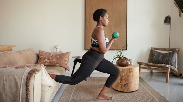 Shot of a young woman exercising at home
