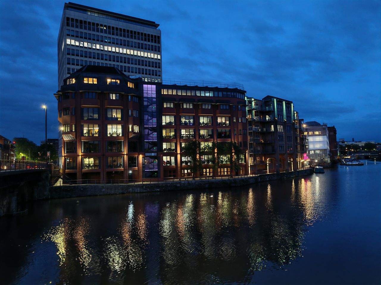 A night shot of a building reflected in the River Avon.