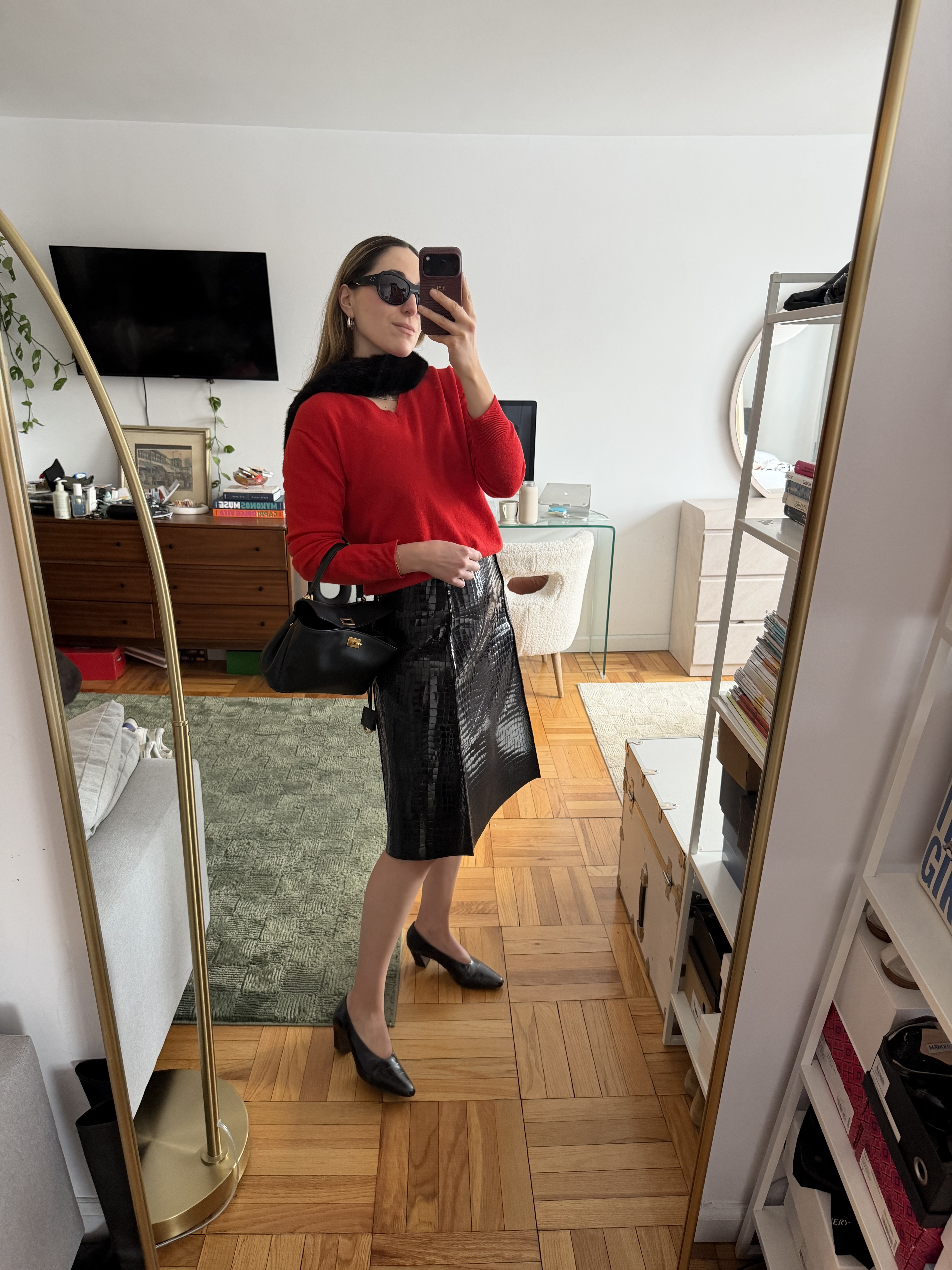 senior fashion editor Anna LaPlaca wearing a red sweater, croc-embossed skirt, fur stole, Balenciaga Rodeo Bag, and almond-toe pumps
