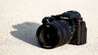 A lifestyle image of the Panasonic Lumix S1R II on a textured tan surface