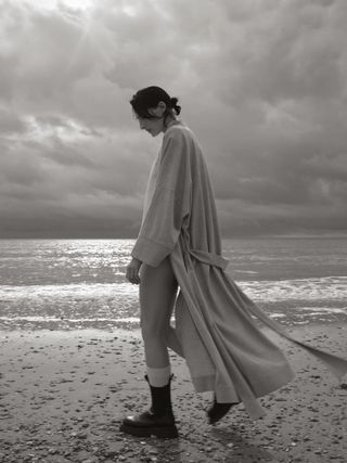 Woman on beach in loungewear and boots