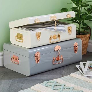 Aldi storage trunks in white and blue on a tiles floor next to a potted plant