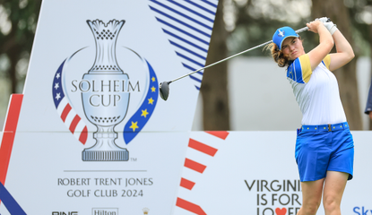 Leona Maguire strikes a driver in front of a Solheim Cup advert