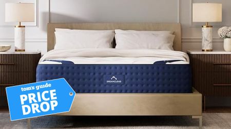 The original DreamCloud mattress in a modern bedroom. There is a deals badge in the bottom left foreground.