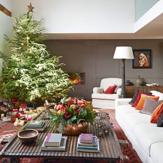 living room with white wall and charismas tree with gifts