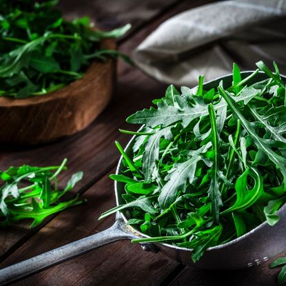 Arugula greens in a metal cup