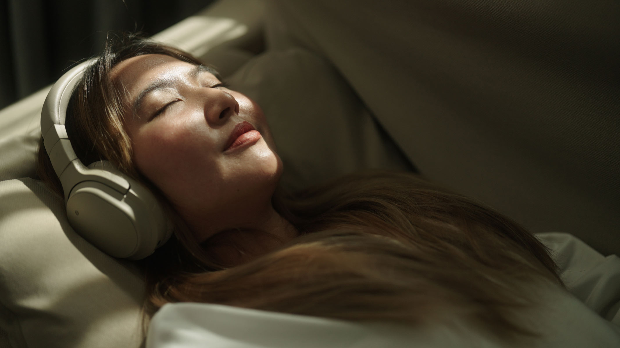 A young woman sleeping with headphones on