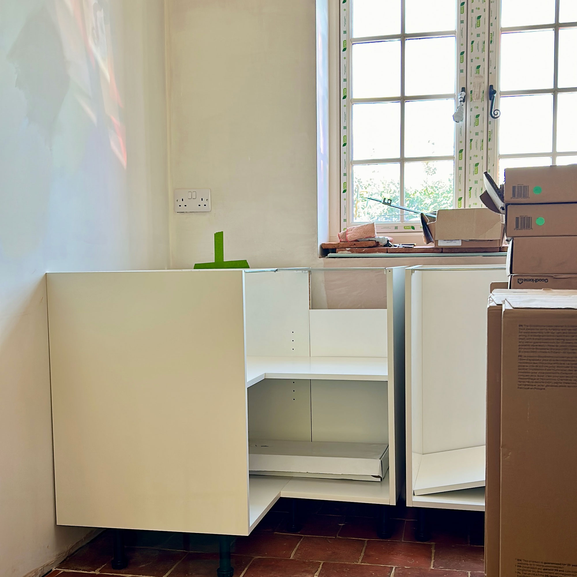 Plain white kitchen units being fitted into kitchen