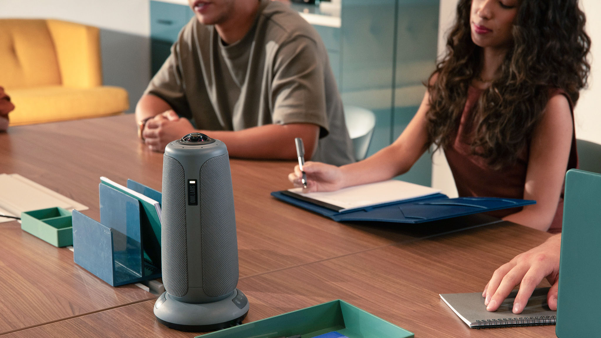 The new Owl Labs 5 meeting solution in the middle of a desk in a small conference room. 