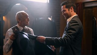 Rudy Quintanilla and Manuel Garcia-Rulfo as a taylor and Mickey in a suit store in The Lincoln Lawyer season 2 episode 5