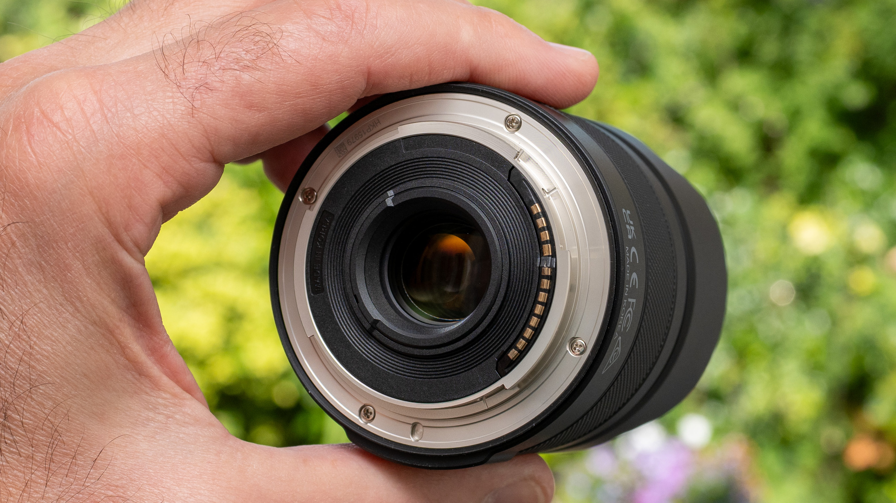 LK Samyang AF 12mm f/2 RF-S product shot lens held in hand