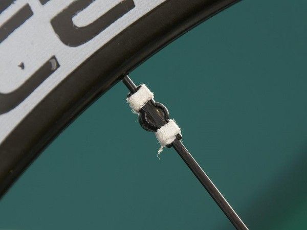 The Shimano-specific spoke magnet usually holds reasonably well on its own but a little tape never hurts when it comes to cobbles.