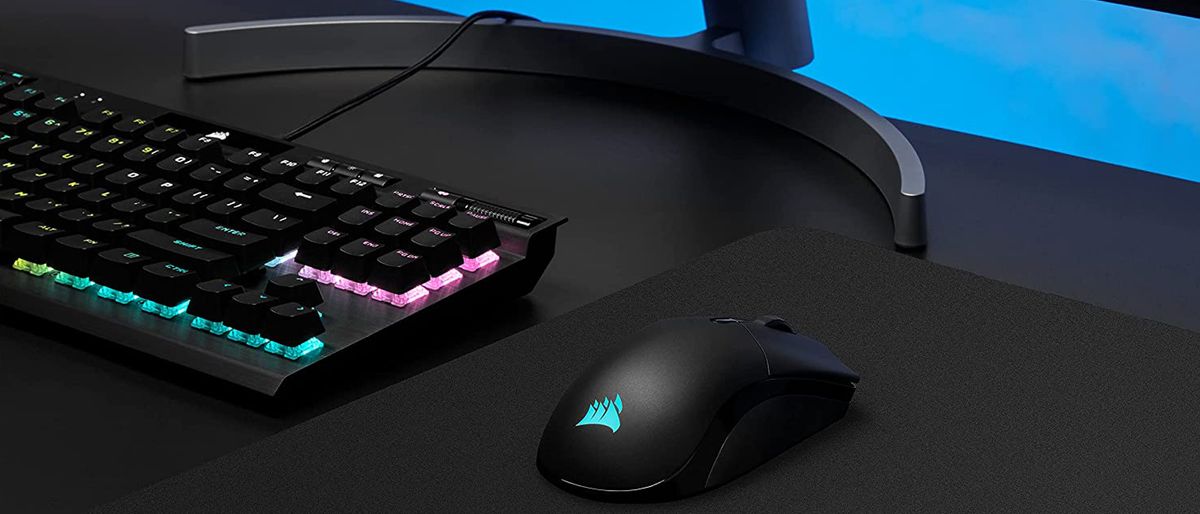 Corsair Sabre RGB Pro Wireless sitting on desk with keyboard